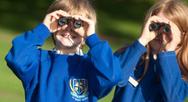 Kids_enjoying_looking_the_park_through_binoculars_signpost