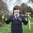 Girl proudly holds up her dibber and some snowdrops